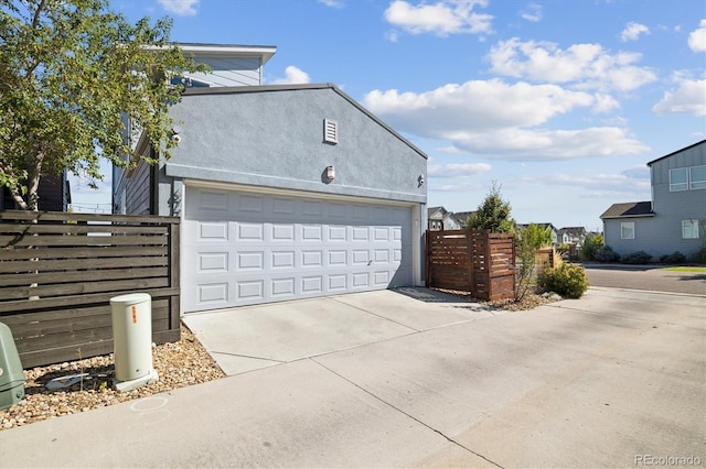 garage with driveway and fence
