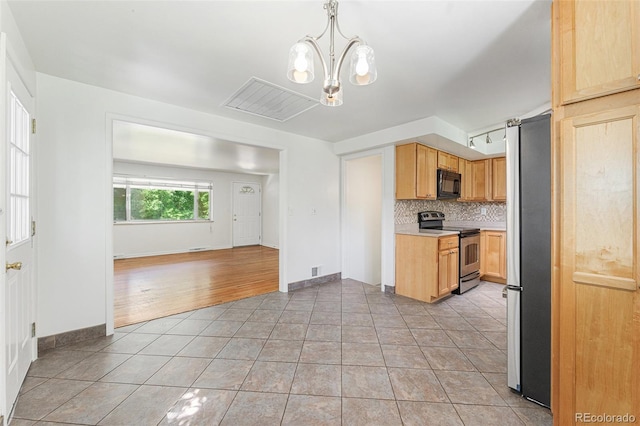 2017 Jackson St, Golden, CO 80401 - kitchen featuring stainless steel appliances, light tile patterned floors, tasteful backsplash, light countertops, and a chandelier