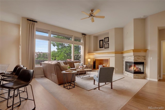 1001 Deer Clover Way, Castle Pines, CO 80108 - living area with a ceiling fan, a stone fireplace, and light wood-style floors