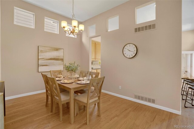 1001 Deer Clover Way, Castle Pines, CO 80108 - dining room with a chandelier, light wood finished floors, and a towering ceiling