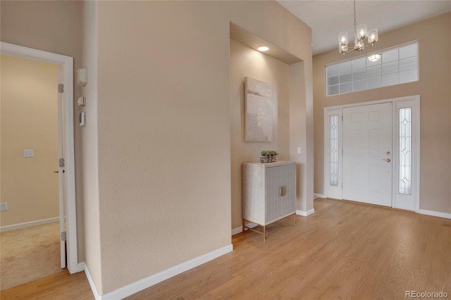 1001 Deer Clover Way, Castle Pines, CO 80108 - entryway featuring a chandelier, light wood-style floors, and a towering ceiling