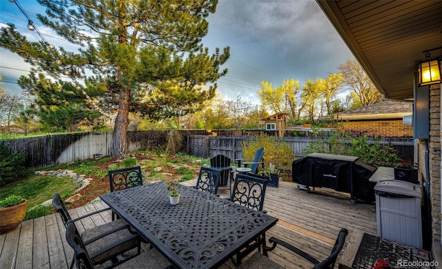 wooden terrace featuring a fenced backyard and outdoor dining space