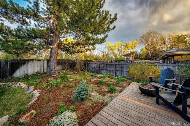 wooden deck with a fenced backyard