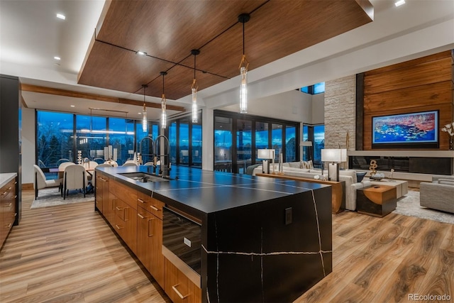 kitchen with open floor plan, modern cabinets, a large island, and light wood finished floors