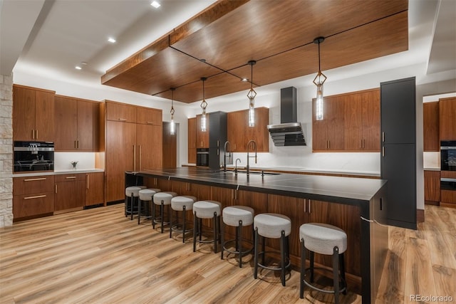 5140 S Kearney Ct, Greenwood Village, CO 80111 - kitchen with wall chimney range hood, oven, light wood-style flooring, and brown cabinets