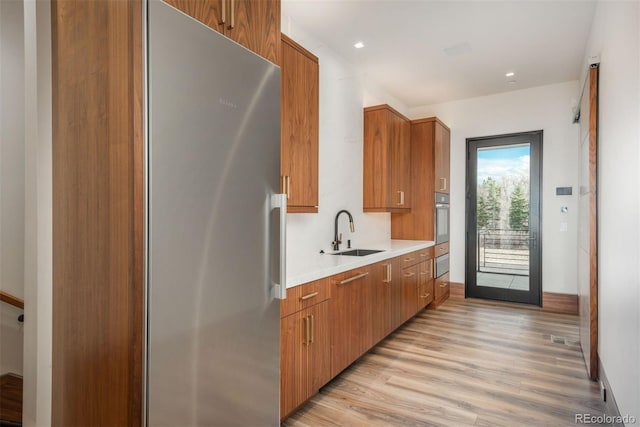 5140 S Kearney Ct, Greenwood Village, CO 80111 - kitchen with a sink, stainless steel appliances, a warming drawer, light wood-style floors, and light countertops