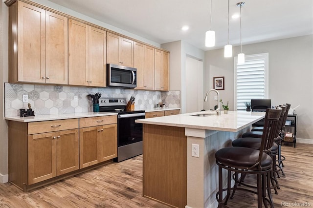 1976 Canyonpoint Ln, Castle Pines, CO 80108 - kitchen with appliances with stainless steel finishes, light wood finished floors, tasteful backsplash, a breakfast bar, and a kitchen island with sink