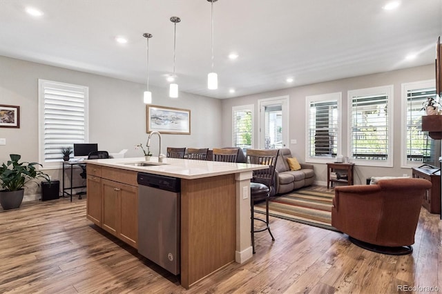 1976 Canyonpoint Ln, Castle Pines, CO 80108 - kitchen with dishwasher, open floor plan, light wood-style floors, a center island with sink, and light countertops