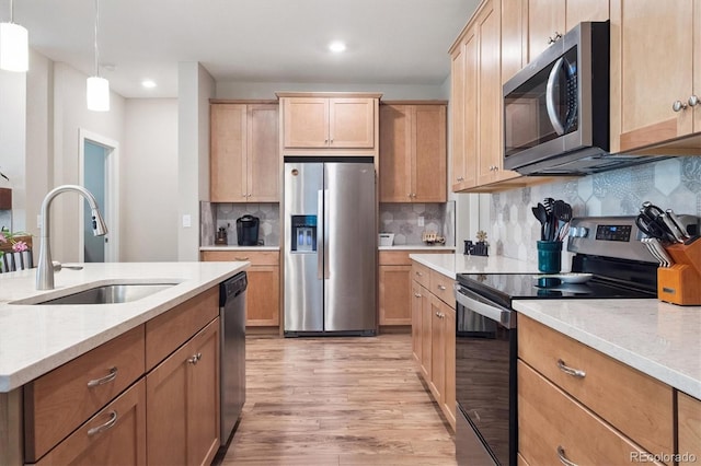 1976 Canyonpoint Ln, Castle Pines, CO 80108 - kitchen with stainless steel appliances, light wood-type flooring, backsplash, recessed lighting, and hanging light fixtures