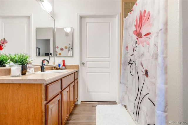 bathroom with wood-type flooring, vanity, and a shower with shower curtain