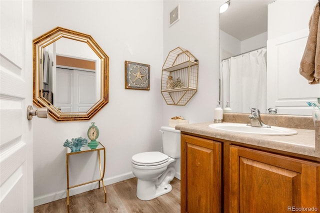 bathroom with vanity, toilet, and wood-type flooring