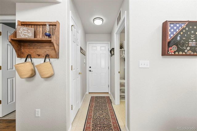 interior space featuring light tile patterned flooring, visible vents, and baseboards