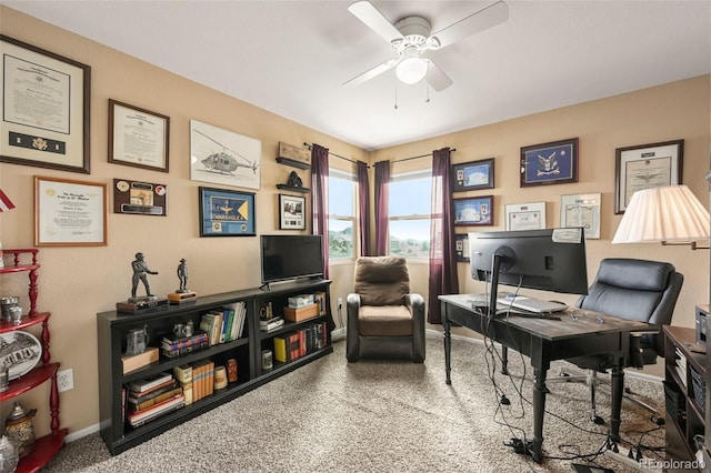 carpeted office space with ceiling fan and baseboards