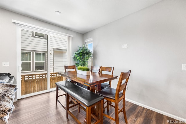 dining space featuring baseboards and dark wood finished floors