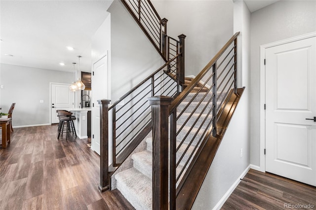 staircase featuring recessed lighting, baseboards, and wood finished floors