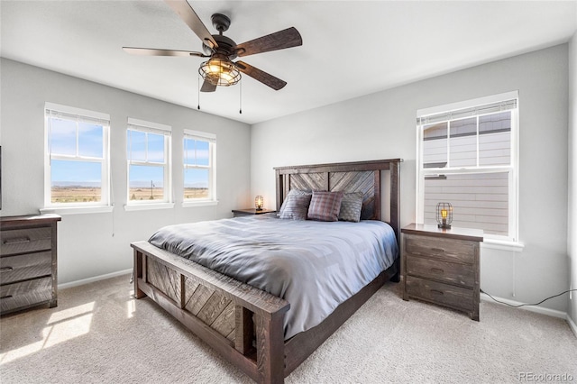 carpeted bedroom with a ceiling fan and baseboards