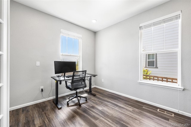 office space featuring baseboards, visible vents, and wood finished floors