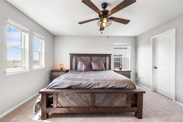 bedroom with a ceiling fan, baseboards, and carpet flooring