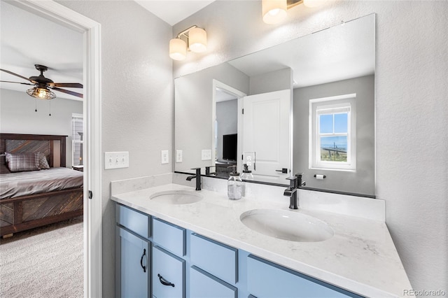 bathroom with a ceiling fan, a sink, ensuite bath, and double vanity