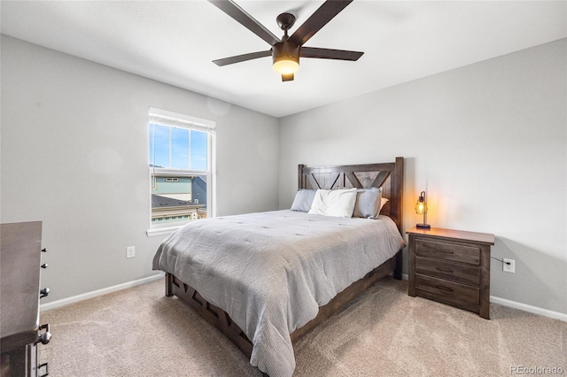 bedroom with light carpet, a ceiling fan, and baseboards