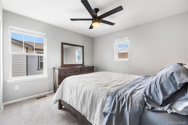 carpeted bedroom with baseboards, visible vents, and a ceiling fan