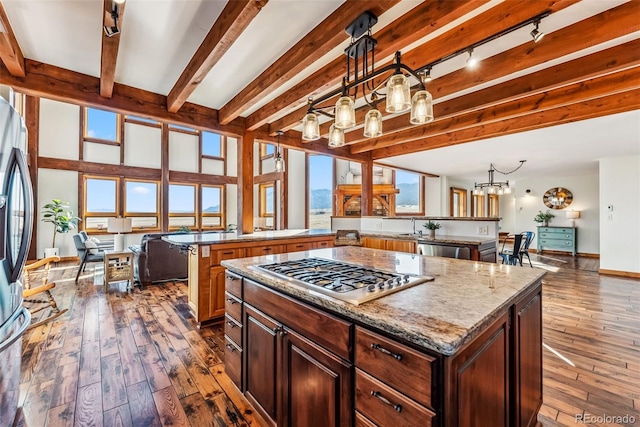 kitchen featuring dark wood-style floors, wine cooler, beamed ceiling, a center island, and appliances with stainless steel finishes