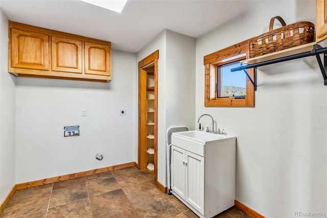 laundry area featuring stone finish floor, a sink, hookup for a washing machine, baseboards, and electric dryer hookup