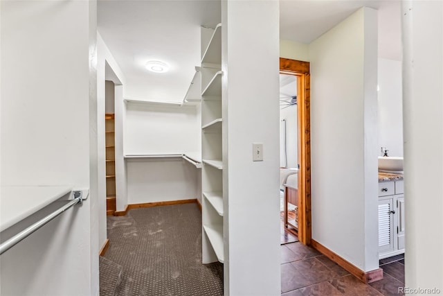 walk in closet with a ceiling fan and a sink