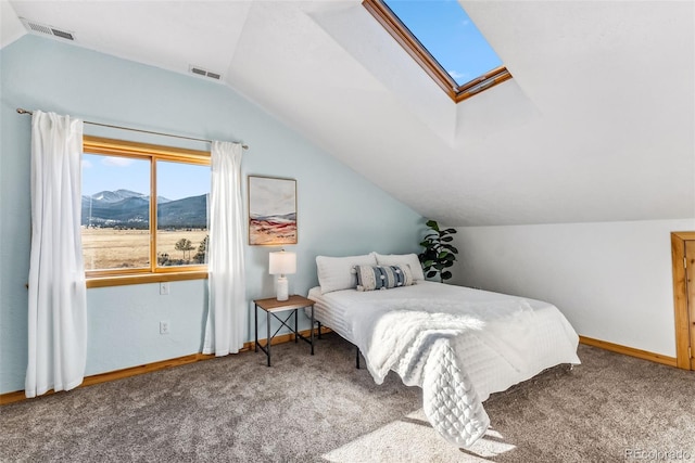 carpeted bedroom with vaulted ceiling with skylight, a mountain view, visible vents, and baseboards