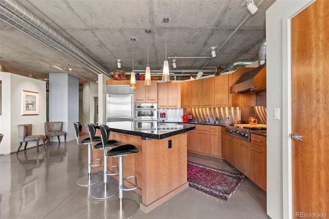 1610 Little Raven St Unit 502, Denver, CO 80202 - kitchen featuring a center island, a kitchen bar, appliances with stainless steel finishes, concrete floors, and brown cabinets
