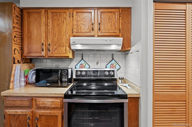 4550 E 121st Pl, Thornton, CO 80241 - kitchen with stainless steel range with electric stovetop, under cabinet range hood, black microwave, and light countertops