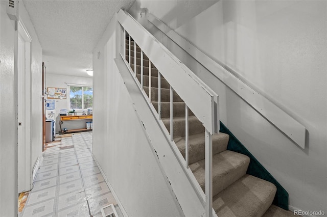 4550 E 121st Pl, Thornton, CO 80241 - staircase featuring a textured ceiling and tile patterned floors
