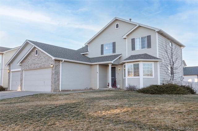 traditional-style home with brick siding, driveway, roof with shingles, a front yard, and an attached garage