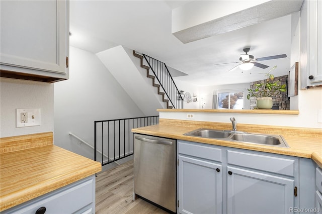 kitchen with light countertops, a ceiling fan, a sink, light wood-type flooring, and dishwasher