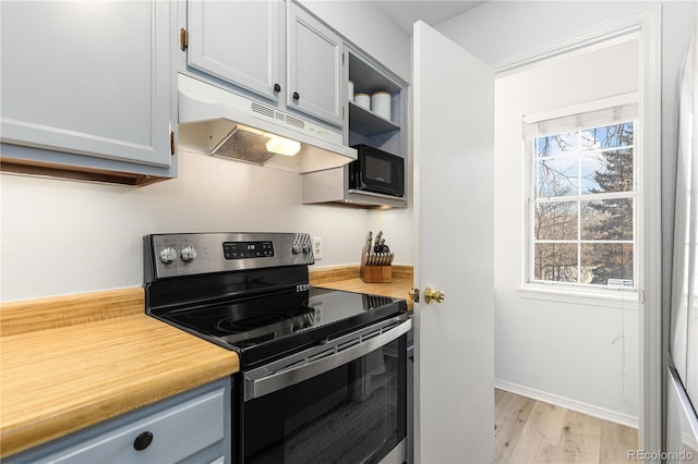 kitchen with light wood-style flooring, under cabinet range hood, light countertops, stainless steel electric stove, and open shelves