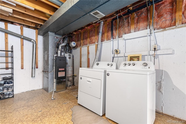 laundry room featuring water heater, laundry area, independent washer and dryer, and visible vents