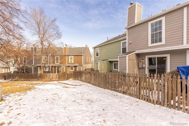 exterior space featuring a chimney, fence, and a residential view