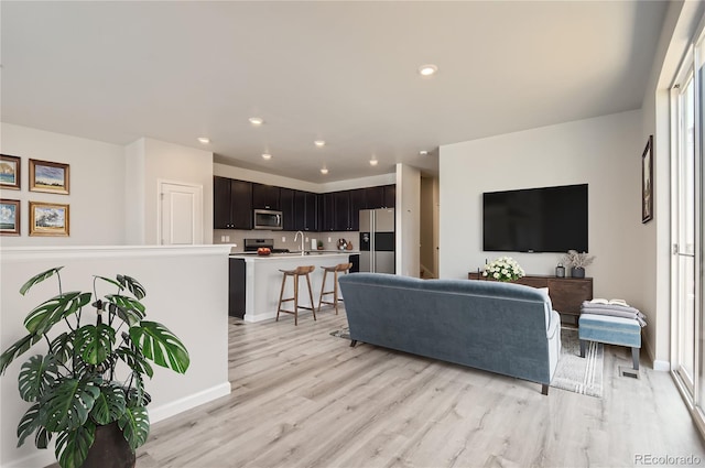 living room featuring sink and light hardwood / wood-style floors