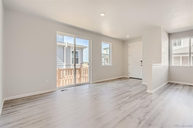 unfurnished room featuring plenty of natural light and light hardwood / wood-style flooring