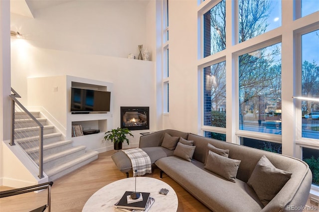 8071 E 29th Ave, Denver, CO 80238 - living room featuring a towering ceiling, wood finished floors, stairs, and plenty of natural light