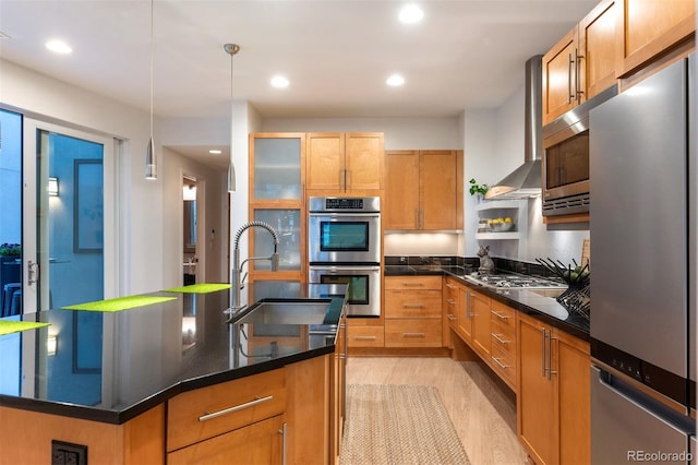 8071 E 29th Ave, Denver, CO 80238 - kitchen with appliances with stainless steel finishes, a sink, light wood-type flooring, a center island with sink, and decorative light fixtures