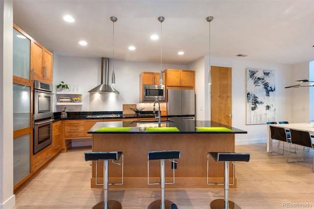 8071 E 29th Ave, Denver, CO 80238 - kitchen with appliances with stainless steel finishes, wall chimney range hood, a sink, dark countertops, and light wood-type flooring