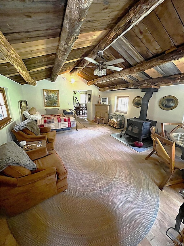 interior space with a wood stove, wood-type flooring, ceiling fan, wooden ceiling, and lofted ceiling with beams