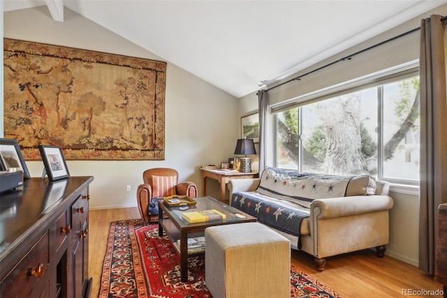 living area featuring lofted ceiling with beams and light hardwood / wood-style floors