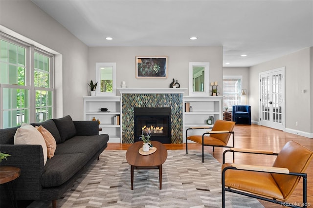 2485 S Fillmore St, Denver, CO 80210 - living room featuring light wood finished floors, recessed lighting, a tiled fireplace, and baseboards