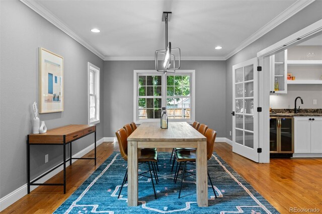 2485 S Fillmore St, Denver, CO 80210 - dining space featuring light wood-style flooring, bar with sink, crown molding, baseboards, and recessed lighting