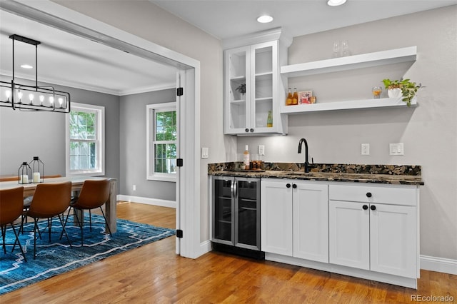 2485 S Fillmore St, Denver, CO 80210 - indoor wet bar featuring wine cooler, light wood-type flooring, baseboards, a chandelier, and crown molding