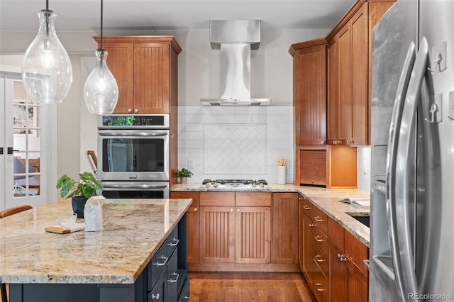 2485 S Fillmore St, Denver, CO 80210 - kitchen with stainless steel appliances, wall chimney exhaust hood, and brown cabinets