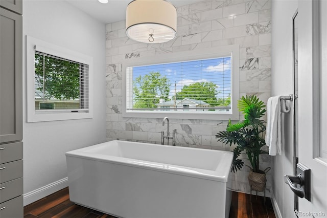2485 S Fillmore St, Denver, CO 80210 - full bathroom with a soaking tub, wood finished floors, and baseboards