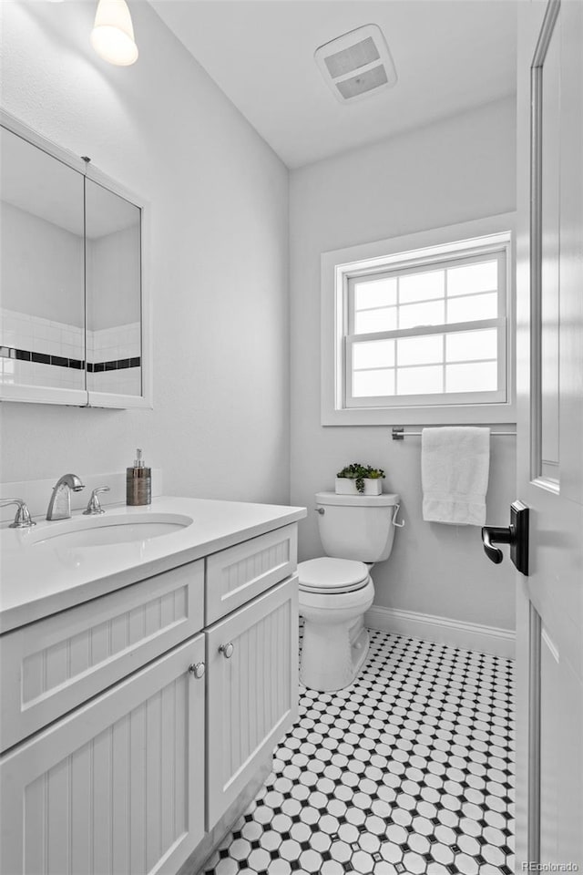 2485 S Fillmore St, Denver, CO 80210 - bathroom with vanity, toilet, baseboards, and tile patterned floors